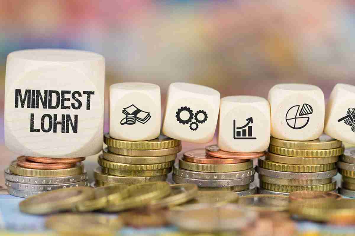 Münzen und Würfel mit Symbolen und Beschriftung Mindestlohn