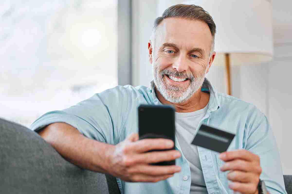 Mann mit Smartphone und Kredikarte